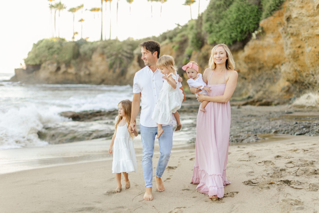Candid shot of family walking on a beach during a relaxed photo session in Orange County.